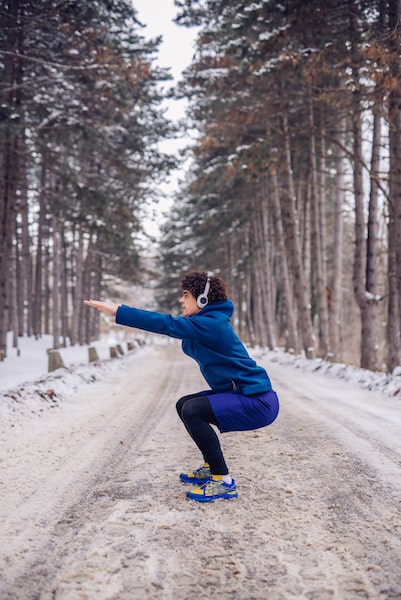 Exercice de squat dans la neige pour une préparation physique pour le ski