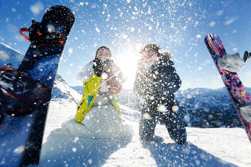 Couple avec snowboard sur les pistes de ski
